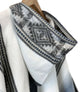 Palora lightweight alpaca wool hooded poncho – a hooded poncho with intricate, geometric gray patterns along the edge, hangs on a wooden hanger, against a plain background