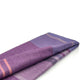 Chuquipata baby alpaca wool blanket – a folded woolen blanket displays shades of purple and pink in a plaid pattern, resting neatly on a plain, white background