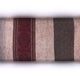 A textile fabric features wide vertical stripes in gray, red, and dark brown, with intricate patterns on the red stripe, set against a blurred white background.