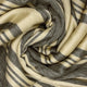 Chalua baby alpaca wool blanket – a soft woolen fabric with grey and cream stripes is intricately swirled, creating a pattern resembling a spiral. The fabric appears cozy and textured