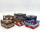 Fabric-covered baskets with colorful geometric patterns are arranged on a plain white background. Patterns feature vibrant shades of blue, red, orange, and brown, creating a lively visual contrast.