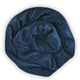 Alpamalag baby alpaca wool blanket – a tightly rolled, soft, dark blue fabric, resembling wool, sits against a plain white background, highlighting its texture and sheen