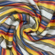 Guayan baby alpaca wool blanket – striped fabric swirled in yellow, red, blue, and gray bands against a white background, creating a dynamic, vibrant pattern filling the entire view