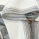 Cuyuja lightweight alpaca wool hooded poncho – poncho is hanging on a wooden hanger, featuring a hood with black and white stripes and a button closure. It appears soft and cozy, suitable for cool weather