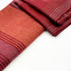 Pallatanga baby alpaca wool blanket – two folded, striped, red and orange woolen blanket rest on a plain white surface, showcasing their rich texture and color gradients
