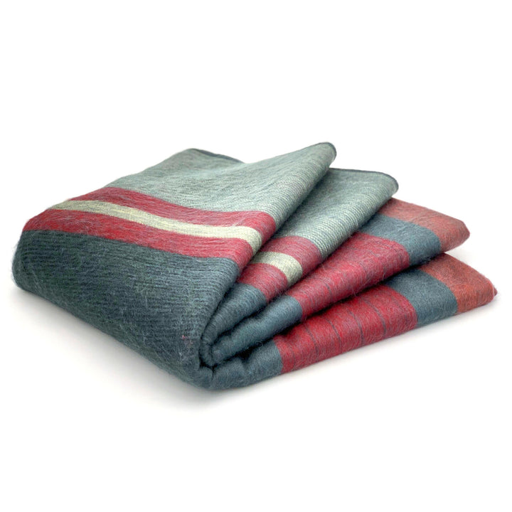 Atacazo baby alpaca wool blanket – a folded blanket with red and gray stripes lies neatly on a white background, showcasing its soft texture and simple design