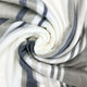 Yacoubina baby alpaca wool blanket – a soft, striped fabric in shades of white, gray, and beige is swirled into a spiral pattern, creating a textured, cozy appearance