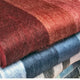 Wholesale lot of 15 queen alpaca wool blankets – two folded, fuzzy blankets with gradient colors, red on top and blue underneath, stacked together, filling the frame