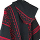 Llama Wool Hooded Poncho – a black fabric with intricate red geometric patterns, featuring a raised collar and distinct woven texture, displayed against a plain white background