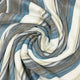 Chuquipogyo baby alpaca wool blanket – a striped fabric in blue, brown, gray, and white is swirled into a spiral pattern, creating a textured, abstract design
