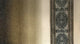The image displays a close-up of a woven textile featuring vertical stripes, including a detailed geometric pattern on several bands, set against a neutral background.