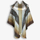 A woolen poncho with geometric patterns drapes elegantly. The fabric features gradations of brown, gray, and beige, set against a contrasting white background.