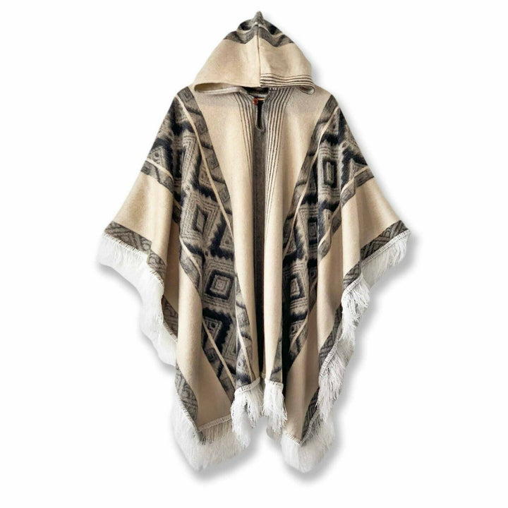 Poncho with a hood, featuring geometric patterns and fringed edges, displayed against a white background. The colors are primarily beige and black with a southwestern design influence.