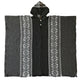 A black woven poncho with white geometric patterns drapes symmetrically on either side of a central closure. It features a hood and is displayed on a plain background.