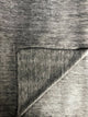 Pilahuin baby alpaca wool blanket – a textured gray fabric with a visible fold in the lower right corner, creating a subtle contrast in the material's weave pattern