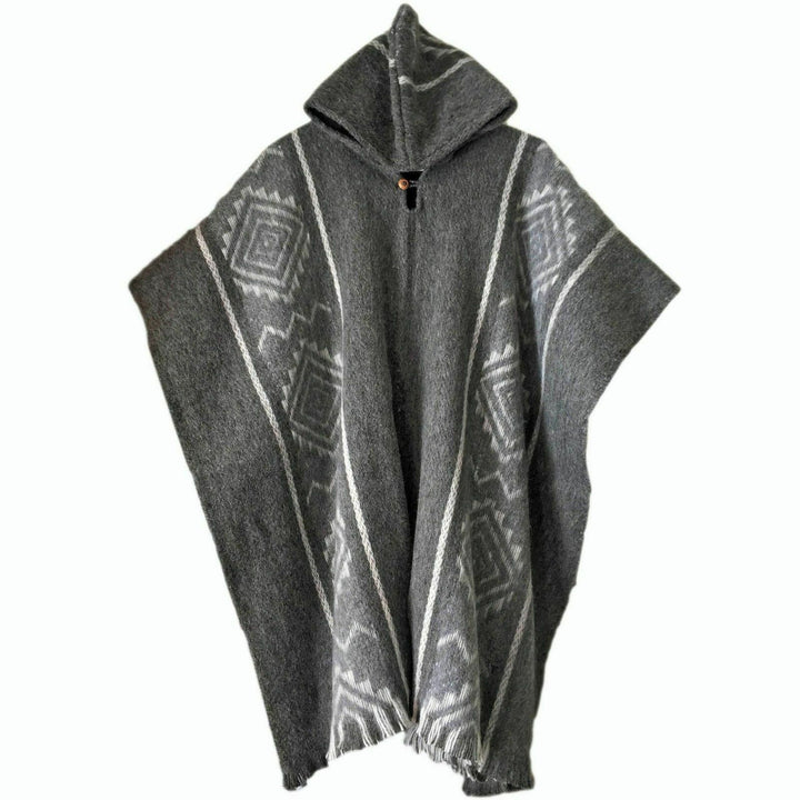 Llama Wool Hooded Poncho – gray poncho with hood; displaying geometric patterns, primarily diamonds and lines. It hangs against a plain white backdrop, showcasing fringed edges and a front button for closure