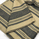 Chalua baby alpaca wool blanket – a folded piece of striped fabric, featuring alternating wide and narrow dark and light bands, lies flat on a white surface