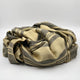 Chalua baby alpaca wool blanket – a crumpled, striped beige and gray fabric lies on a plain, light background, suggesting a soft texture and relaxed appearance