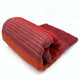 Pallatanga baby alpaca wool blanket – a folded red and orange striped blanket rests neatly on a white surface. The varying shades create a textured, warm appearance, suggesting coziness and comfort