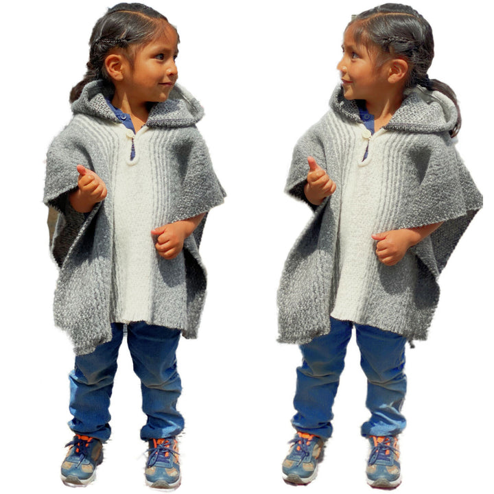 Zuleta llama wool hooded poncho – two young children, both wearing grey hooded poncho and blue jeans, face each other and smile. They stand on a plain white background, with no text present