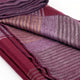 Pallatanga baby alpaca wool blanket – a folded, multicolored wool blanket with shades of burgundy and purple displays a striped pattern, resting on a smooth surface