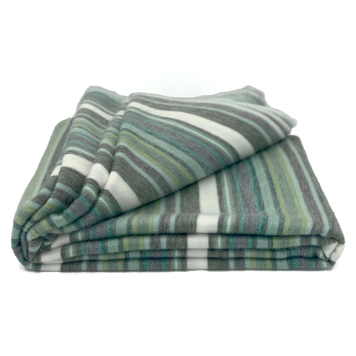 Urauco baby alpaca wool blanket – a folded, striped blanket with hues of green, grey, and white rests on a plain white background, emphasizing its soft texture and pattern