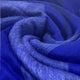Chibuleo baby alpaca wool blanket – soft, intertwined blue fabric creates a swirling pattern, displaying varying shades and textures. The material appears thick and plush, suggesting warmth and comfort in its presentation