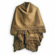 A brown blanket hangs vertically, featuring intricate woven patterns and fringed edges. It is set against a plain, light background.