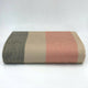Tilivi baby alpaca wool blanket – a folded, multicolored wool blanket features beige, pink, and gray stripes lying flat against a plain white background