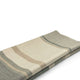 Deleg baby alpaca wool blanket – a folded, striped blanket lies flat, featuring beige and green tones. The texture appears soft and woven. The background is plain white, providing a clean contrast