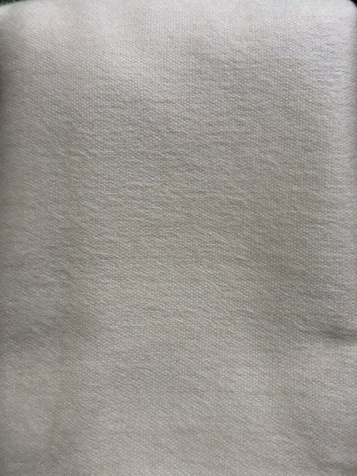 Pilahuin baby alpaca wool blanket – a close-up of a textured, fabric-like surface with a light beige color. The material appears soft, and the image is taken in natural lighting