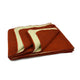 A folded, reversible blanket displays rust-colored and cream layers, arranged neatly on a white background, highlighting its thick and cozy texture.