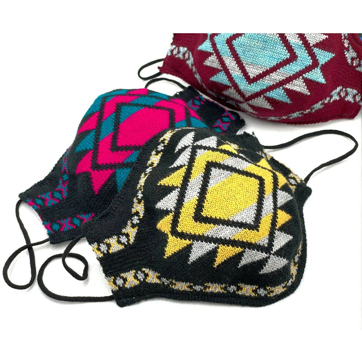 Colorful knitted face masks with geometric patterns in yellow, pink, and blue are displayed overlapping on a white background, showcasing distinctive designs and black ear loops.