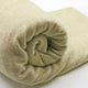Llullalo baby alpaca wool blanket – a soft, cream-colored blanket is rolled neatly, showcasing its plush texture, set against a plain white background