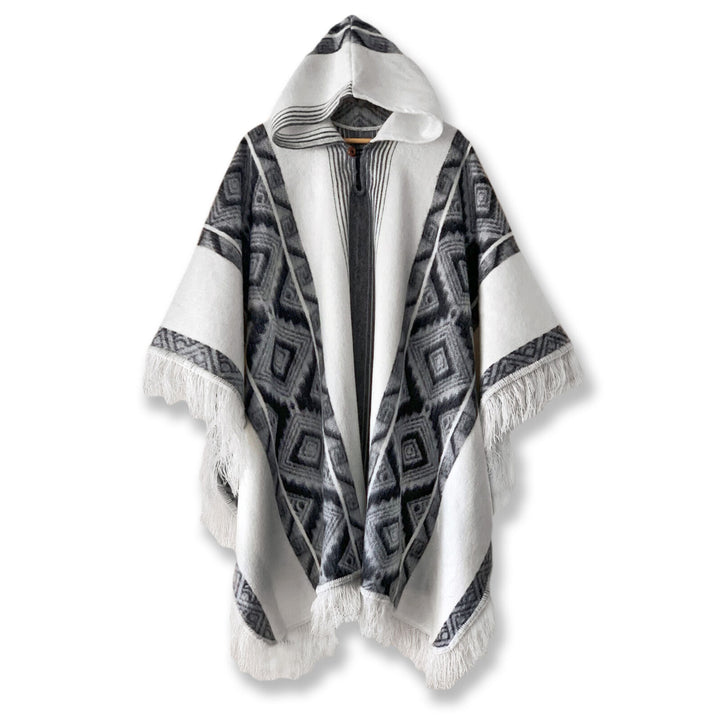 Cuyuja lightweight alpaca wool hooded poncho – a hooded wool poncho displays a black and gray geometric pattern with fringe edges, draped flat against a white background, highlighting its intricate design and cozy texture