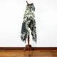 Tarqui alpaca wool hooded poncho – a patterned poncho drapes over a wooden mannequin stand, displaying a geometric design. It stands on a polished wooden floor against a white background
