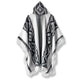 Cuyuja lightweight alpaca wool hooded poncho – a hooded poncho with geometric diamond patterns in black and white hangs against a plain background. Fringed edges give it a traditional look