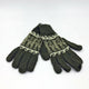 Green knit gloves lay intertwined, featuring a white snowflake and reindeer pattern across the wrist area, set against a plain white background.
