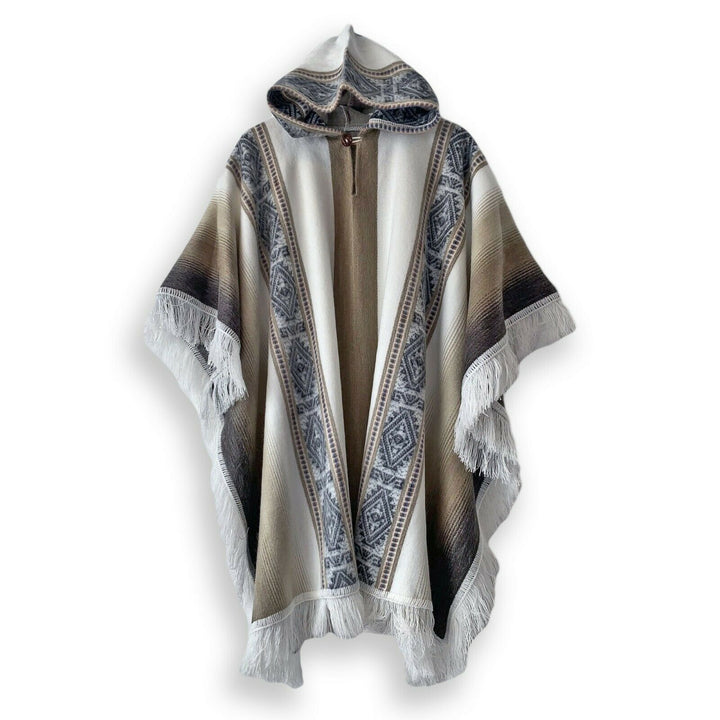 A poncho with a hood, featuring intricate geometric patterns and fringed edges, is displayed against a white background. The design includes earthy tones with a central open front.