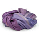 Chuquipata baby alpaca wool blanket – purple and lavender blanket, loosely crumpled, features subtle striped patterns. It rests on a plain white background, highlighting the fabric’s varied textures and soft hues