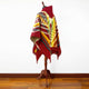 Guismi alpaca wool hooded poncho – a colorful patterned poncho with geometric designs rests on a wooden stand, displayed against a plain white wall and wooden floor