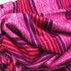 Cayetana baby alpaca wool blanket – fabric with vivid pink and purple stripes lies in soft folds; the material appears textured and layered, creating a vibrant, eye-catching pattern