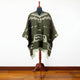 Clint Eastwood alpaca wool poncho – a poncho with geometric patterns is displayed on a mannequin in a room with wooden flooring, against a plain white wall