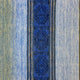 A textured denim fabric features a central dark blue stripe with intricate geometric diamond patterns, bordered by light blue sections, creating a contrasting and decorative textile design.