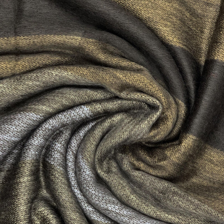 Yatzaputzan baby alpaca wool blanket – a textured fabric, featuring shades of brown and gray, is arranged in a swirl pattern, creating a sense of movement and depth within the woven material