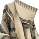 A woven fabric with geometric patterns in black and beige drapes smoothly, featuring a hood with striped detailing, set against a plain background.