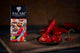 Chocolate bar packaging labeled Pacari Premium Organic Chocolate with chile, placed on a wooden board. In front, sliced red chiles in a small dish; whole chiles in the background.