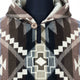 A wool sweater displays a geometric pattern with earth tones, featuring triangles and diamonds. The sweater has a hood and a single button at the neckline, set against a plain background.