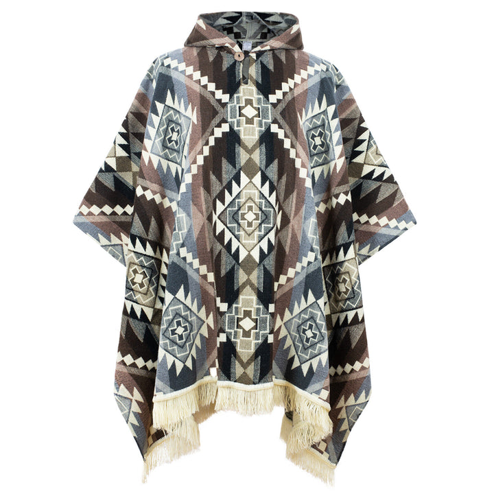 A hooded poncho displays an intricate geometric pattern in blue, brown, and white tones with fringed edges, set against a plain background.