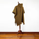 A poncho with a yellow and black diagonal striped pattern is displayed on a wooden stand. It is in a room with a wooden floor and white wall.